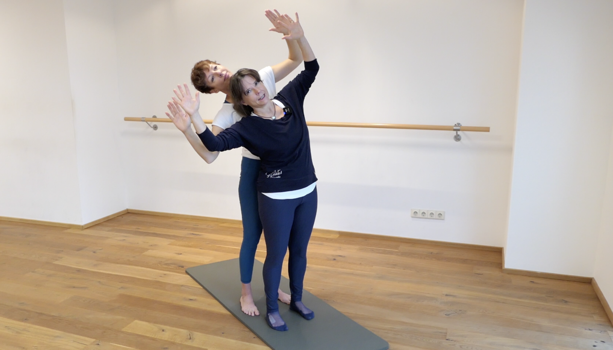 Kerstin Bredehorn und Jenni Karies stehen mit zur Seite geneigtem Oberkörper hintereinander. Ihre Arme zeigen angewinkelt nach oben.